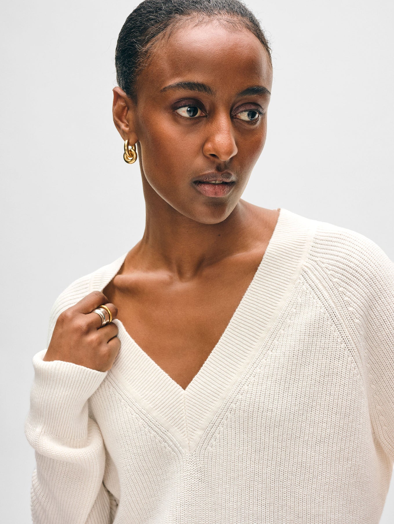 Model wearing white cotton v neck sweater.